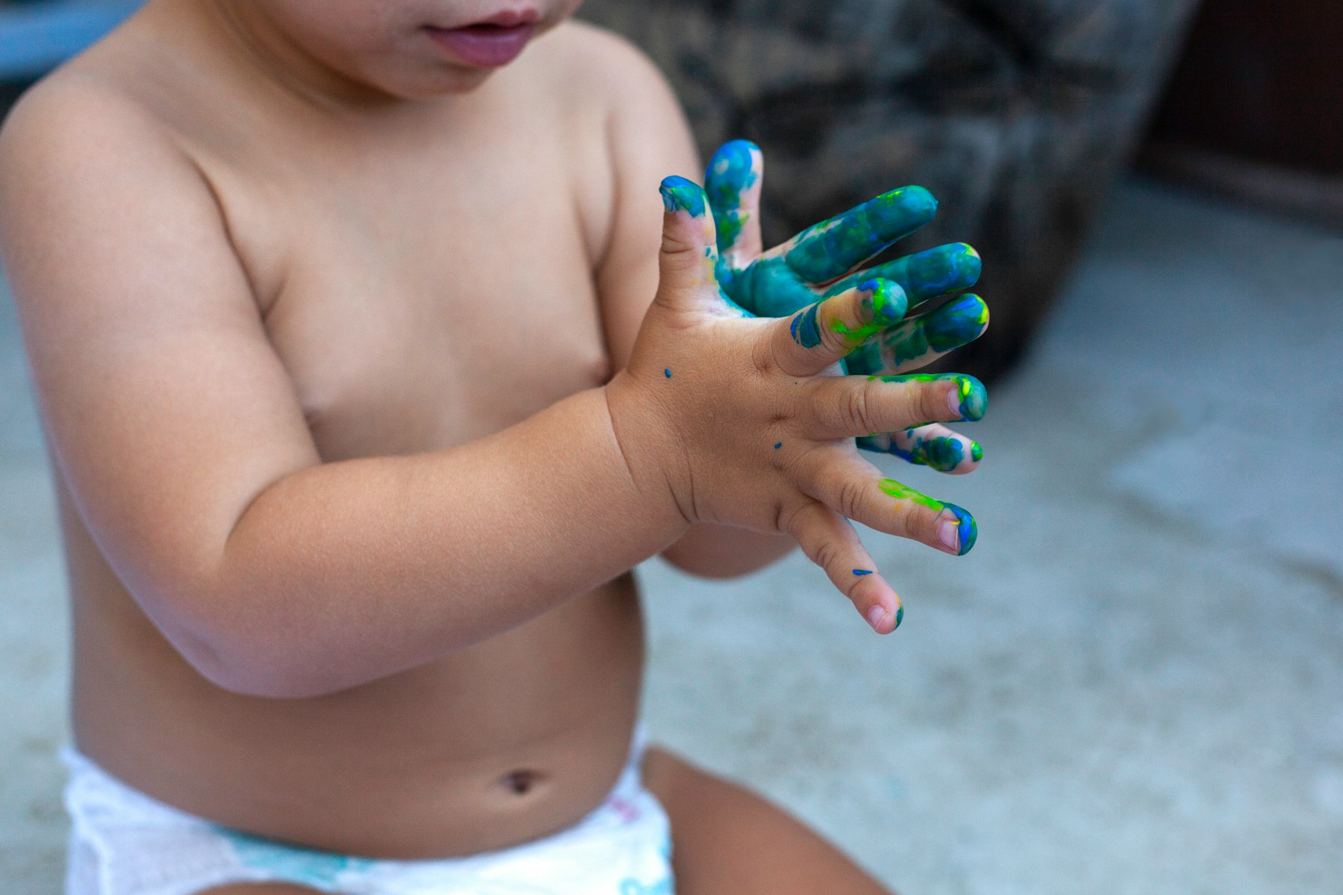 topless child with green manicure